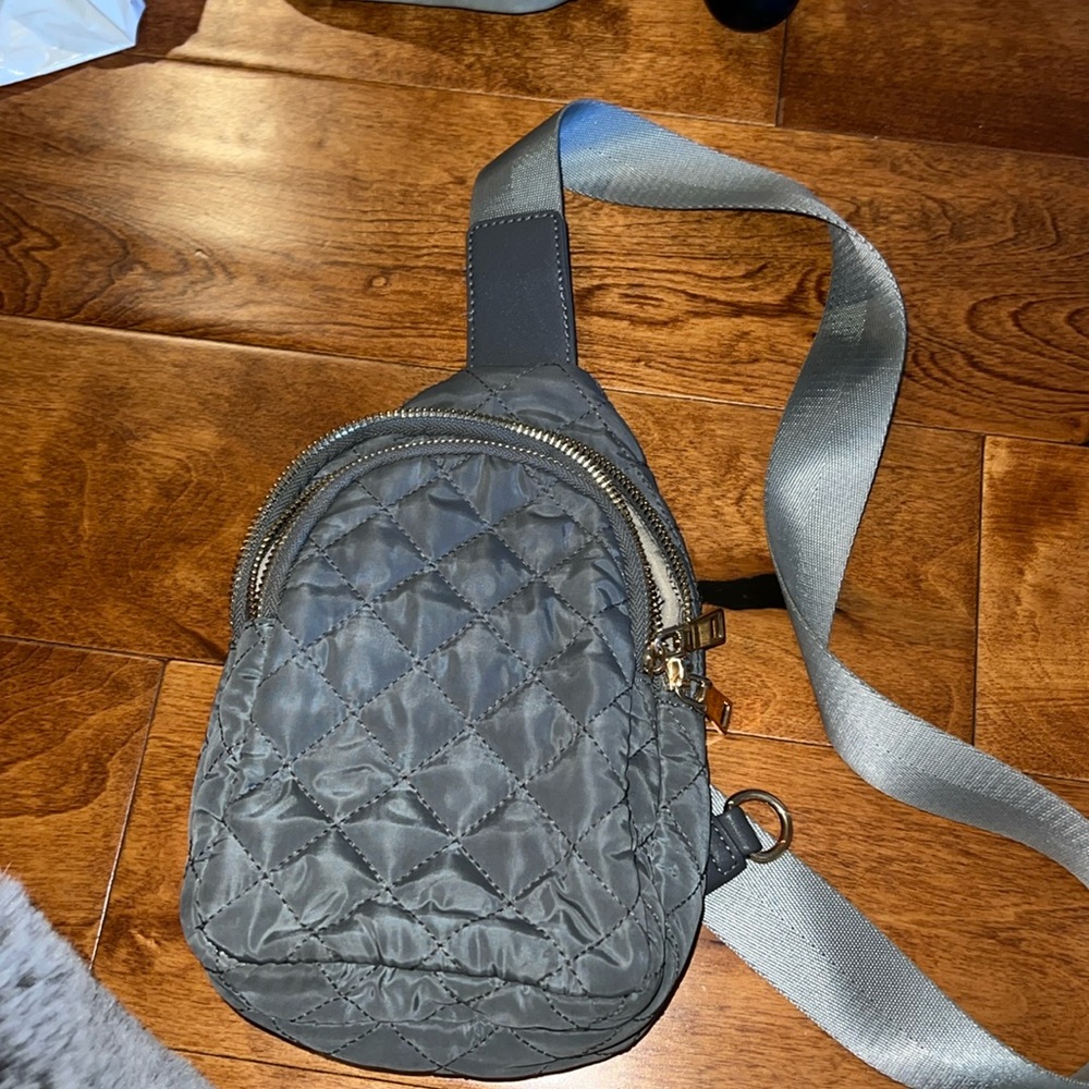 Gray cross potty backpack, adjustable strap. Dual zipper compartments.